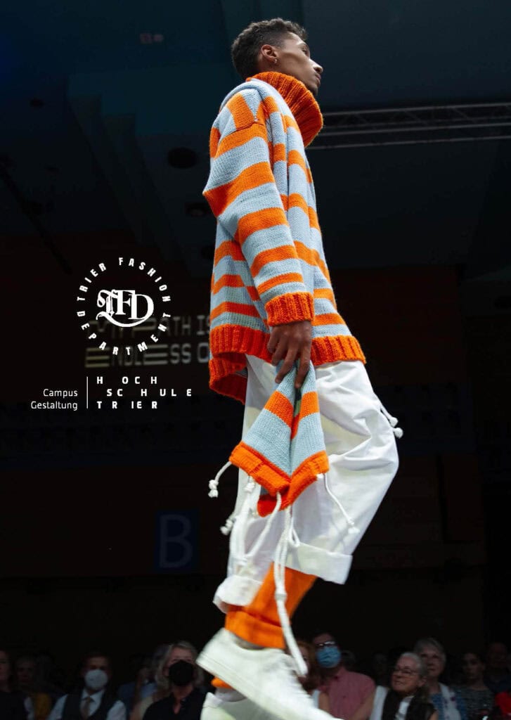 Laufstegmodell in übergroßem orange-blauen Strickpulli von Evelyn Kett